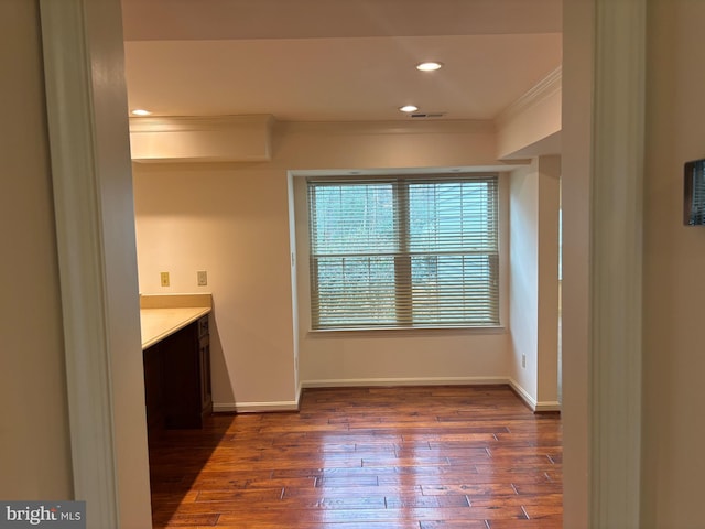 interior space with dark hardwood / wood-style floors and ornamental molding