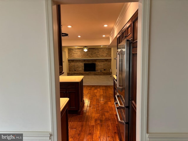 hall featuring crown molding, brick wall, and dark hardwood / wood-style floors