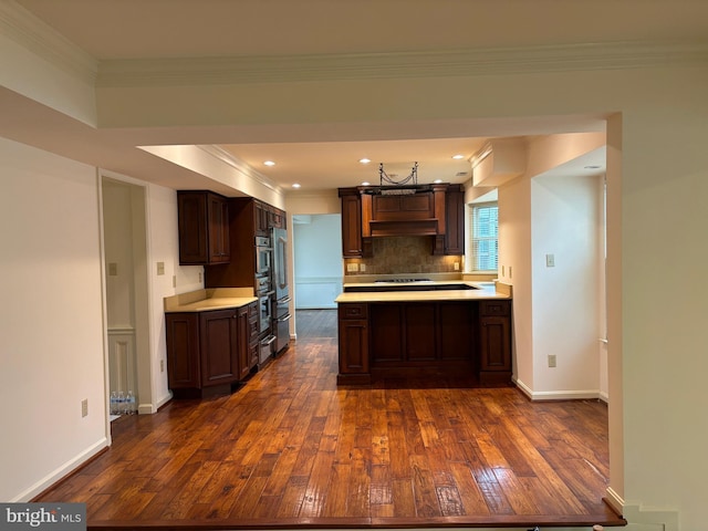 kitchen featuring dark brown cabinets, exhaust hood, dark hardwood / wood-style floors, and ornamental molding