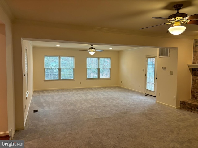 unfurnished living room with crown molding, a fireplace, ceiling fan, and light colored carpet