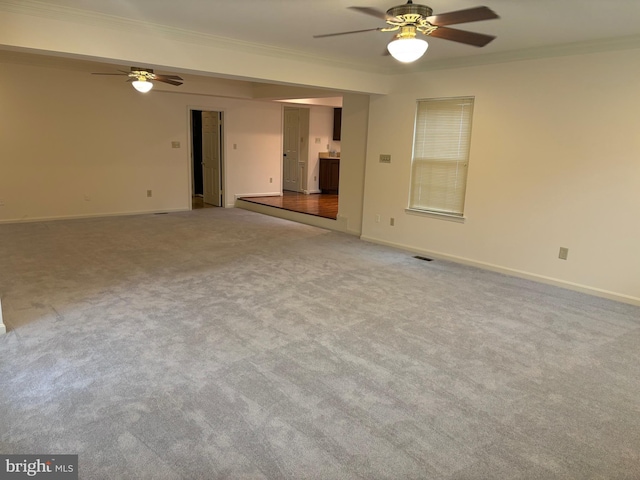 carpeted spare room featuring ceiling fan and ornamental molding