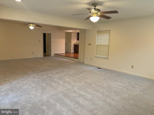 unfurnished room featuring light colored carpet, ceiling fan, and crown molding