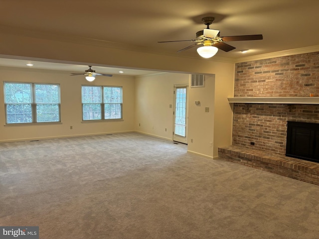 unfurnished living room with light colored carpet, a brick fireplace, ceiling fan, and crown molding