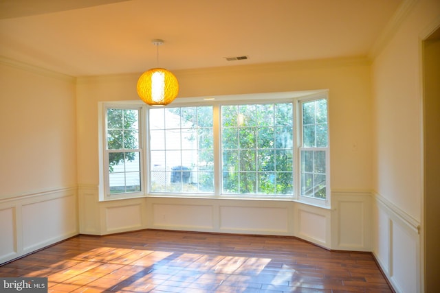 unfurnished dining area featuring wood-type flooring and ornamental molding