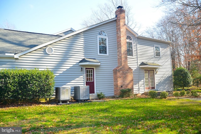 back of property featuring a yard and central air condition unit