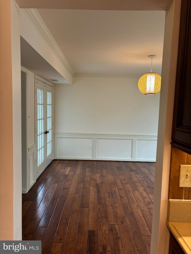 empty room with dark hardwood / wood-style floors, ornamental molding, and french doors