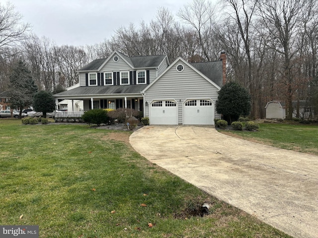 view of front of home with covered porch, a front yard, and a garage