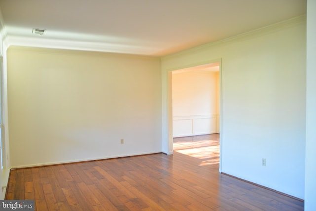 unfurnished room featuring hardwood / wood-style flooring and ornamental molding