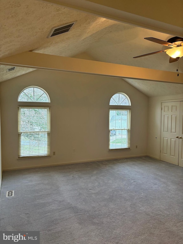 spare room with carpet flooring, lofted ceiling with beams, and ceiling fan