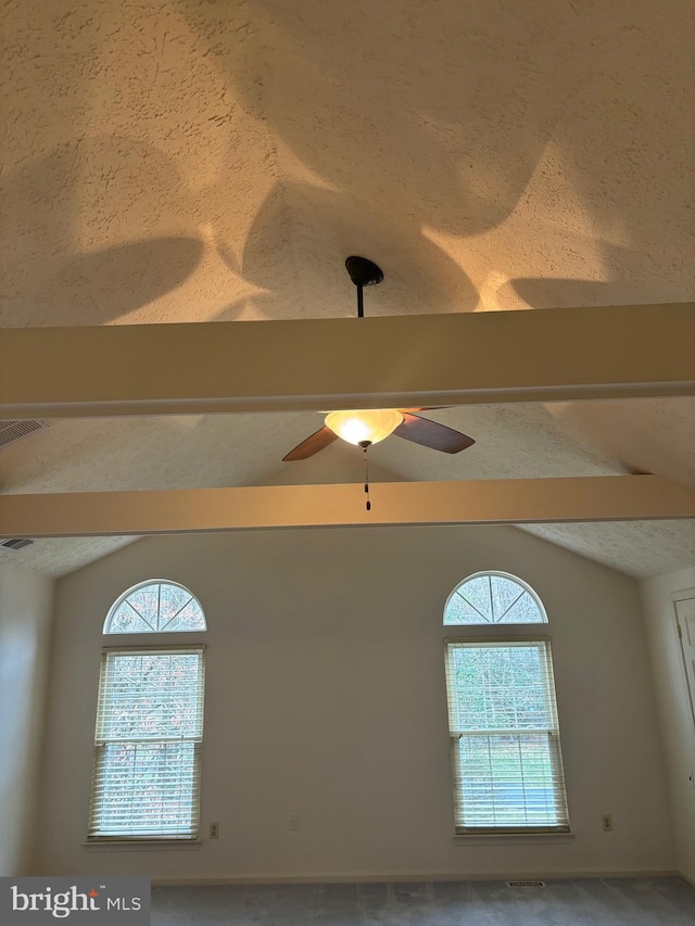 interior details featuring beam ceiling, a textured ceiling, and ceiling fan