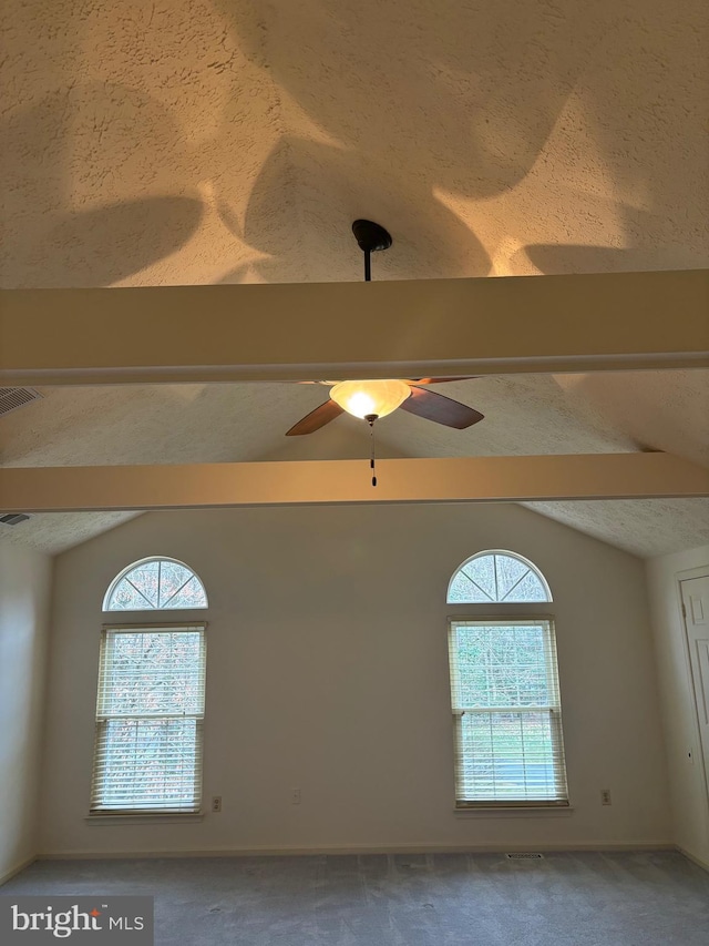 room details featuring beamed ceiling, a textured ceiling, carpet floors, and ceiling fan