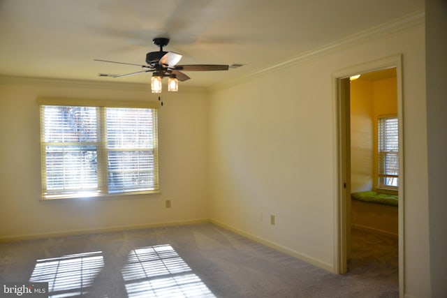 carpeted spare room featuring ceiling fan and crown molding