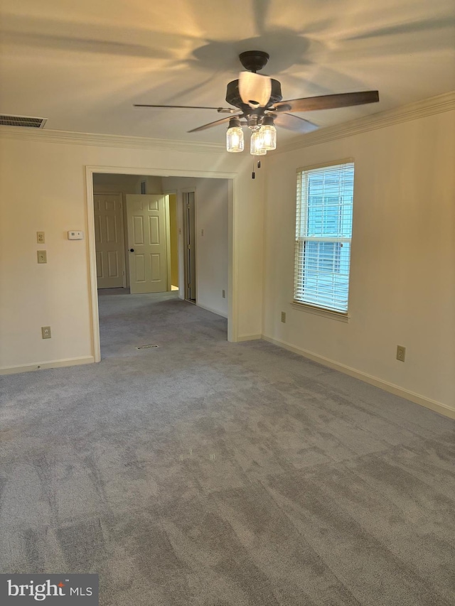 carpeted spare room with ceiling fan and ornamental molding