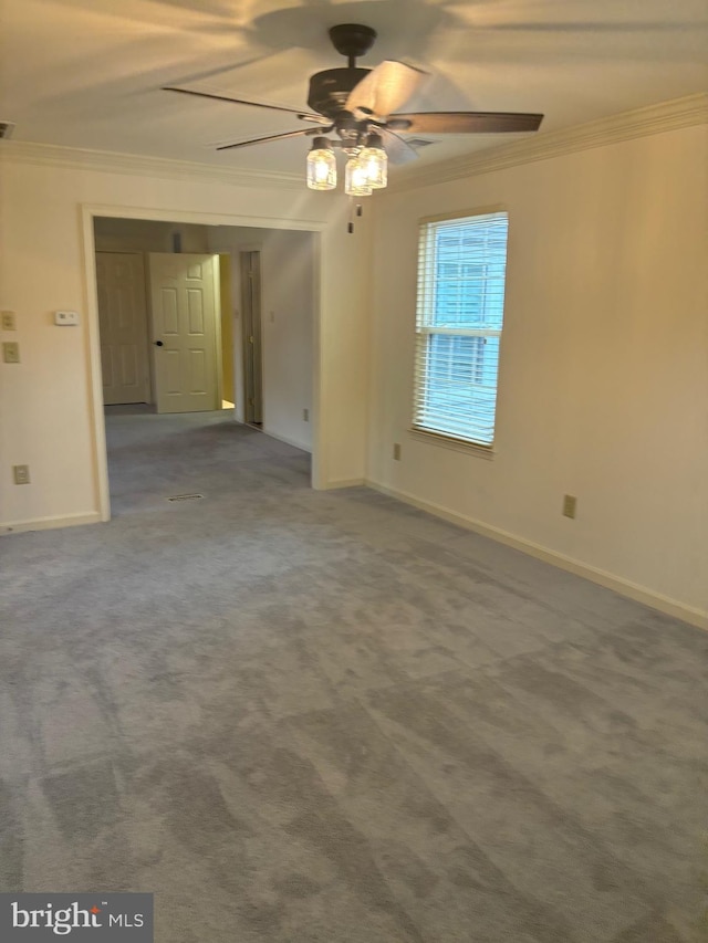 carpeted empty room with ceiling fan and crown molding