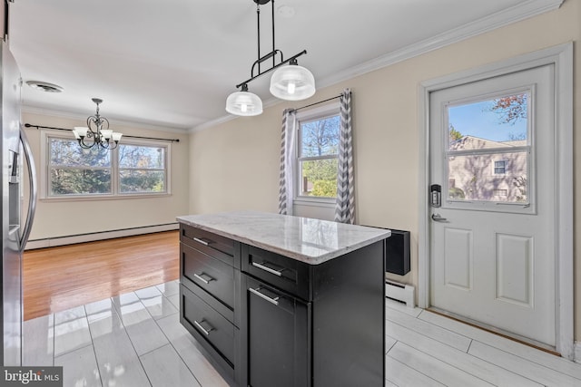 kitchen featuring a center island, a healthy amount of sunlight, baseboard heating, and light hardwood / wood-style flooring