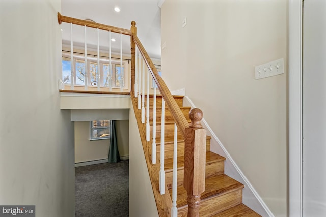 staircase featuring carpet and a baseboard heating unit