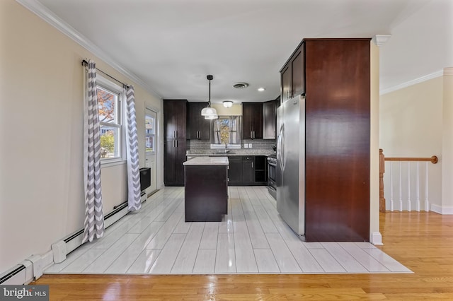 kitchen featuring light hardwood / wood-style flooring, a kitchen island, stainless steel appliances, and decorative light fixtures