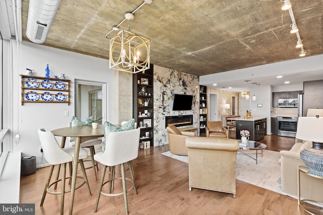 living room with a premium fireplace, hardwood / wood-style floors, and a chandelier