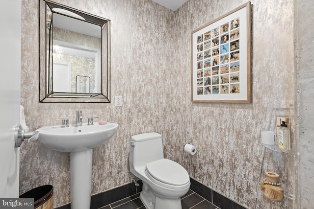 bathroom featuring tile patterned flooring, toilet, and sink