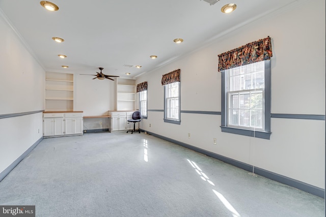 spare room with ceiling fan, built in features, and crown molding