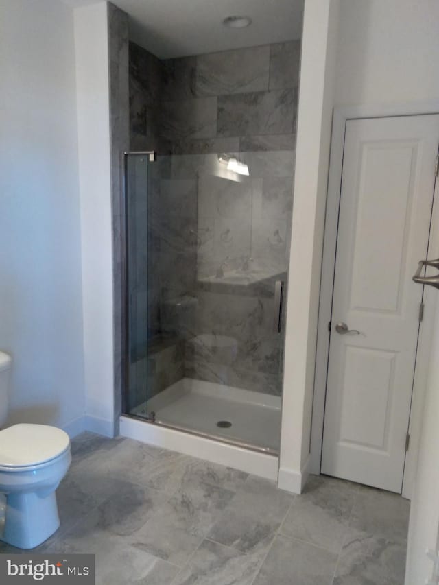 bathroom with an enclosed shower and toilet