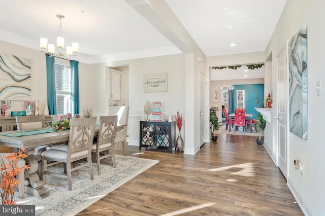 dining space featuring dark hardwood / wood-style flooring, crown molding, and an inviting chandelier