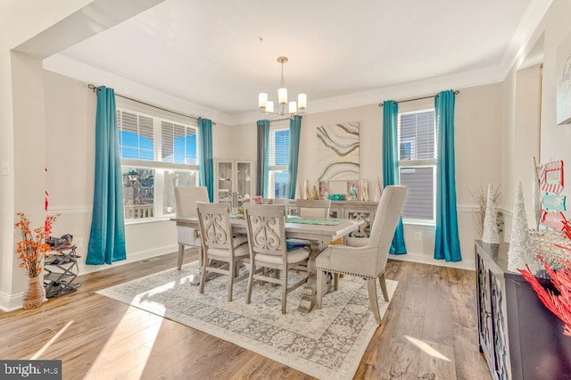 dining room featuring ornamental molding, a notable chandelier, and light wood-type flooring