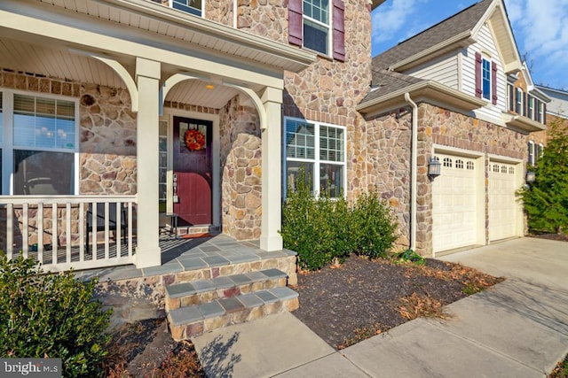 doorway to property featuring a garage and covered porch