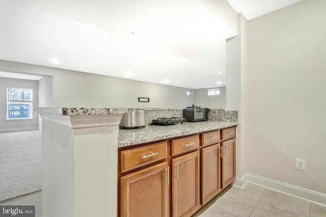 kitchen featuring light tile patterned floors and light stone countertops