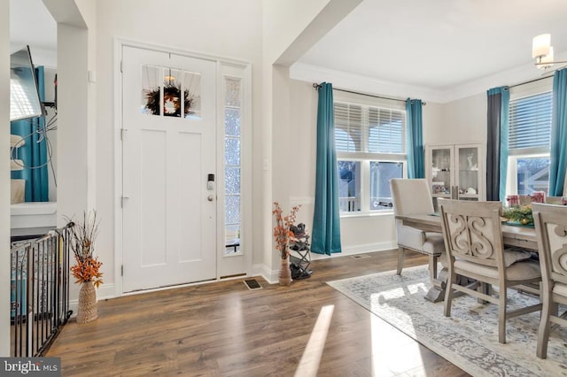 entrance foyer featuring ornamental molding and dark hardwood / wood-style floors