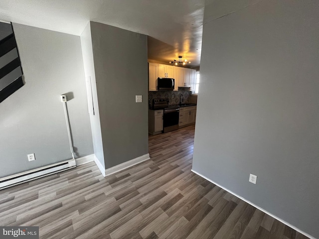 living room with sink, a baseboard radiator, and light hardwood / wood-style flooring