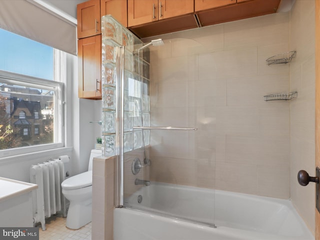 full bathroom featuring vanity, radiator heating unit, shower / bath combination with glass door, and toilet