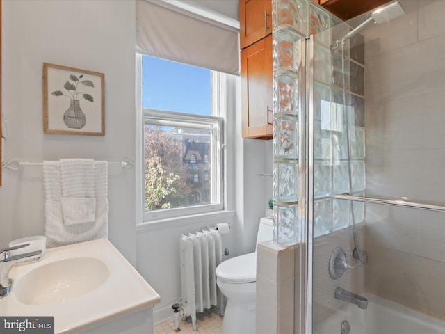 full bathroom featuring sink, radiator heating unit, enclosed tub / shower combo, and toilet