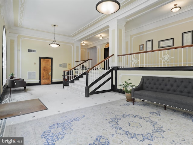 entrance foyer featuring crown molding and ornate columns