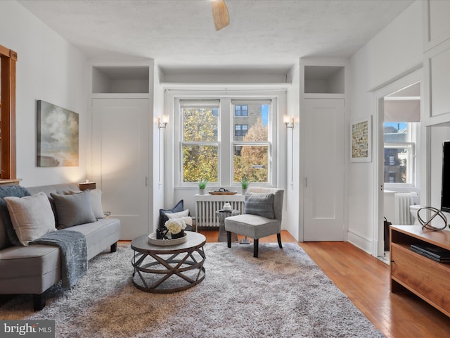 sitting room featuring radiator, a textured ceiling, and light hardwood / wood-style floors