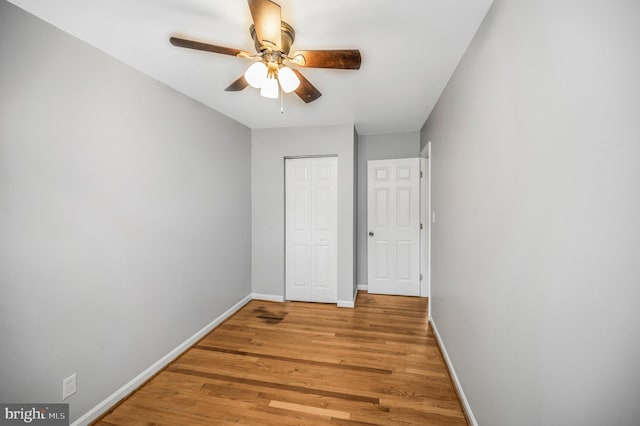 unfurnished bedroom featuring ceiling fan, light wood-type flooring, and a closet