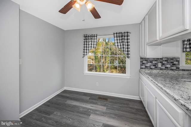 unfurnished dining area featuring dark hardwood / wood-style floors and ceiling fan