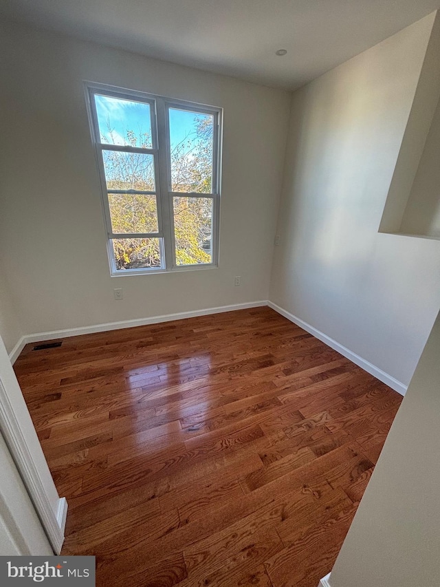 spare room with dark hardwood / wood-style floors