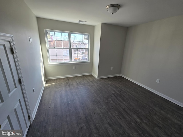 unfurnished room with dark wood-style floors and baseboards