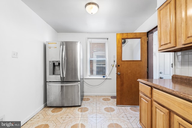 kitchen featuring decorative backsplash, stainless steel fridge, and light tile patterned flooring