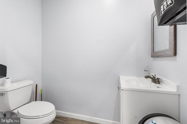 bathroom with wood-type flooring, vanity, and toilet