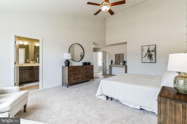 carpeted bedroom featuring ceiling fan, high vaulted ceiling, and ensuite bathroom