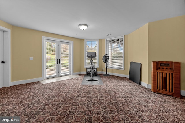 workout room with dark colored carpet and french doors