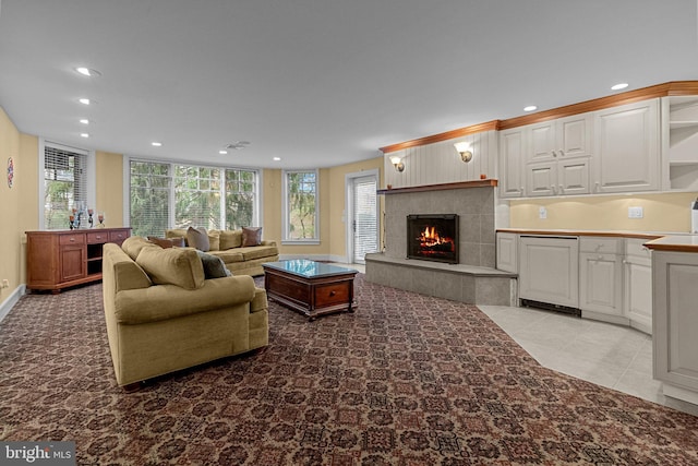 tiled living room featuring a wealth of natural light and a tile fireplace