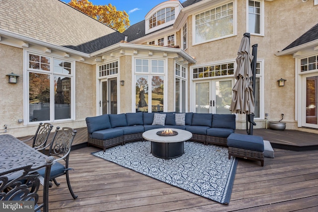 wooden terrace featuring an outdoor living space with a fire pit and french doors