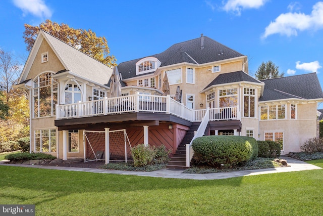 back of house featuring a deck and a lawn