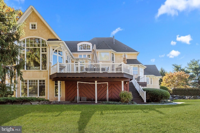 rear view of house with a yard and a deck