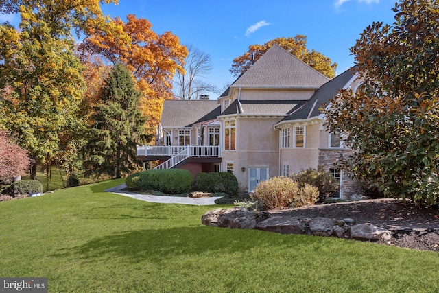 rear view of house featuring a yard and a deck