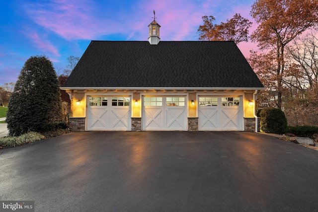 view of garage at dusk