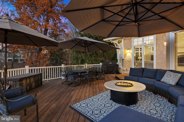 deck with a grill and an outdoor living space with a fire pit